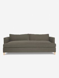 a gray couch with two pillows on it's back and one arm folded up