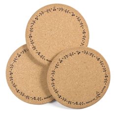 three round cork coasters with leaves on them