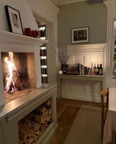 a fire place in the middle of a room filled with books and wine bottles on shelves