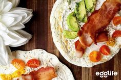 two eggs with bacon, tomatoes and avocado are on tortilla shells