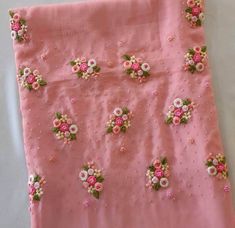 a pink cloth with flowers and pearls on it