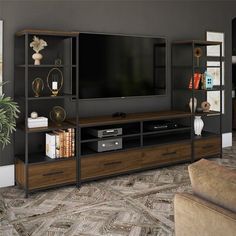 a living room with a large television on top of a wooden entertainment center next to a couch