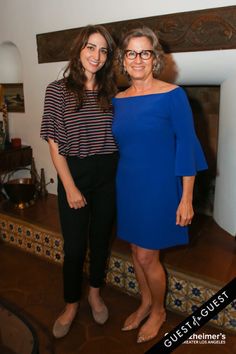 two women standing next to each other in front of a fireplace