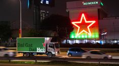 cars driving down the road in front of a building with a large star on it