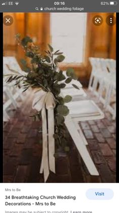 a bouquet of flowers sitting on top of a wooden table next to white folding chairs