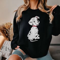 a woman wearing a black sweater with a dalmatian dog on it's chest