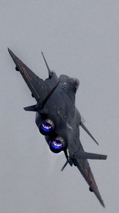 a fighter jet flying through the air with blue lights on it's side and four propellers