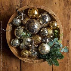 a wooden bowl filled with ornaments on top of a table