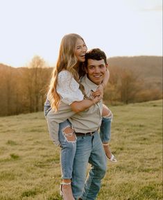 a man carrying a woman on his back in a field