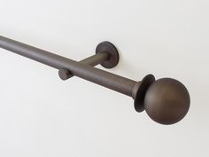 an image of a metal curtain rod with two knobs on the end and one in the middle