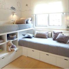 a bedroom with bunk beds and stuffed animals on the shelves in front of the window