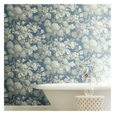 a bath tub sitting under a window next to a wallpaper covered in white flowers