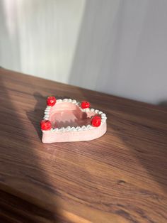 a small heart shaped object sitting on top of a wooden table