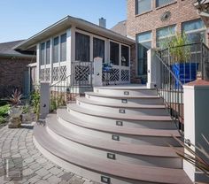 a house with steps leading up to the front door and patio area in the foreground