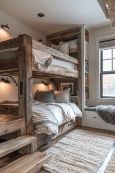 a bedroom with bunk beds and pillows on top of the bed in front of a window