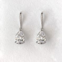 A simple and universally flattering teardrop shaped crystal drop earring is the perfect finishing touch on your wedding day. Our simulated diamonds are AAA+ quality for maximum sparkle. Length: 1 1/4", Width: 1/2" Stones measure 10mm x 14mm 8 carat total weight Carat total weight based on diamond equivalent Custom gift box and microfiber storage pouch included Diamond Teardrop Earrings With Sparkling Stones, Simple Drop Earrings, Classic Drop Bridal Earrings For Wedding, Hypoallergenic Diamond Earrings For Wedding, Teardrop Diamond Crystal Earrings With Prong Setting, Teardrop Crystal Earrings With Prong Setting, Teardrop Crystal Diamond Earrings With Sparkling Stones, Diamond Teardrop Crystal Earrings With Diamond Accents, Classic Crystal Earrings With Diamond Accents For Wedding