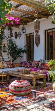 an outdoor living area with colorful rugs and potted plants