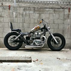 a black and silver motorcycle parked in front of a brick wall next to concrete steps