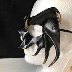 DESCRIPTIONMystify the mortals at the Halloween masquerade with a gold-tipped, black leather vampire mask! Perfect for masquerade parties or theatre productions. Get this gold-tipped mask for Halloween or Vampire Masquerade. A sexy costume accessory for your vampire costume, and a fantastic festival mask! Add to a RenFaire costume. Any color. Waterproofed leather, glossy or matte finish, & several choices to affix the mask (cord, elastic, ribbon, waterproof cord, stick, or no holes for adhesive) Leather Vampire, Renfaire Costume, Dark Fairy Costume, Vampire Mask, Fantasy Festival, Masquerade Mask Black, Festival Mask, Fantasy Ball, Black Masquerade