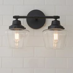 two light fixtures mounted on a white tiled wall