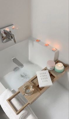 a bath tub with candles and soap in it