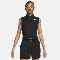 a woman wearing black shorts and a nike polo shirt