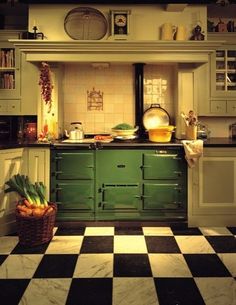 an old fashioned kitchen with green cabinets and black and white checkerboard flooring