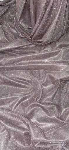 an up close shot of a shiny fabric with silver glitter on the top and bottom