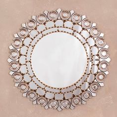 a round mirror on the wall with many circles around it and one circle is surrounded by smaller circular mirrors