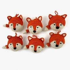 six knitted fox ornaments are shown on a white surface