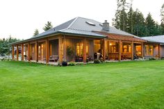 a house that is in the middle of some grass and has lights on it's windows