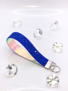 a blue and silver object with some diamonds on the ground in front of white background