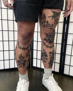 a man's legs with tattoos on them