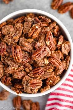 a white bowl filled with pecans on top of a red and white striped napkin