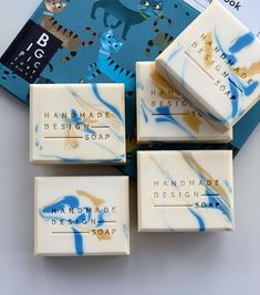 four soap bars sitting next to each other on top of a blue and white table