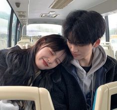 two people sitting on a bus with their heads close to each other's shoulders