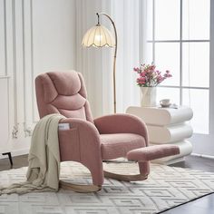 a pink recliner chair sitting on top of a rug in front of a window