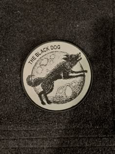 the black dog sticker is sitting on top of a jacket with an image of a fox