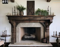 an old fireplace with potted plants and candles on the mantel above it in a living room