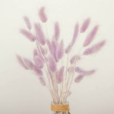 purple feathers in a glass jar on a table