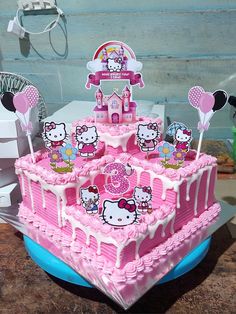 a pink hello kitty birthday cake on a table