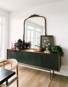 a living room with a large mirror on the wall and wooden furniture in front of it