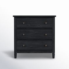 a black dresser with three drawers and two knobs on the bottom, against a white background