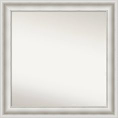 a white framed mirror with silver trimmings on the edges and an ornate border around it