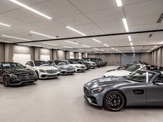 a bunch of cars are parked in a garage with lights on the ceiling and overhead lighting