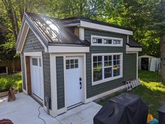 a small house with a black roof and white doors