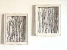 two framed pictures hanging on the wall next to each other with branches drawn in them