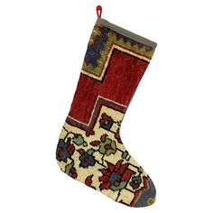 a christmas stocking hanging on a white wall with a red ribbon attached to it