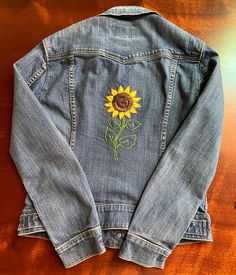 This Sunflower Blue Jean Jacket is the perfect piece for any casual look. Made of high-quality denim, this jacket is designed to provide comfort and style. The Adult Small size is perfect for anyone looking for a classic, slightly fitted denim jacket. The classic sunflower blue hue is a timeless look that will never go out of style. Add this essential piece to your wardrobe today and enjoy its timeless style. Blue Embroidered Relaxed Fit Outerwear, Blue Embroidered Outerwear With Relaxed Fit, Embroidered Relaxed Fit Denim Jacket, Casual Embroidered Cotton Outerwear, Denim Blue Long Sleeve Outerwear With Floral Embroidery, Long Sleeve Denim Blue Outerwear With Floral Embroidery, Casual Outerwear With Floral Embroidery, Denim Blue Floral Embroidery Long Sleeve Outerwear, Embroidered Denim Blue Outerwear For Fall