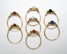 These rings are Gold Filled. They are size 8.5, tied wire rings, made from one piece of gold filled wire which passes through the stone and 3 mm gold filled bead accents. The stone choices are 4 mm rounds, 5-6 mm long oval or cylinder or freshwater pearl. ( sizes are approximate) Handmade by us.     Want a different size, stone or one in Sterling Silver? Contact us.     Lyn's Jewelry, in business operating out of Sunny Syracuse since 1989. Wire Wrapped Jewelry Tutorials, Gold Gemstone Ring, Rings Gold, Wire Rings, Beads And Wire, Beaded Rings, Jewelry Tutorials, Wire Wrapped Jewelry, Freshwater Pearls